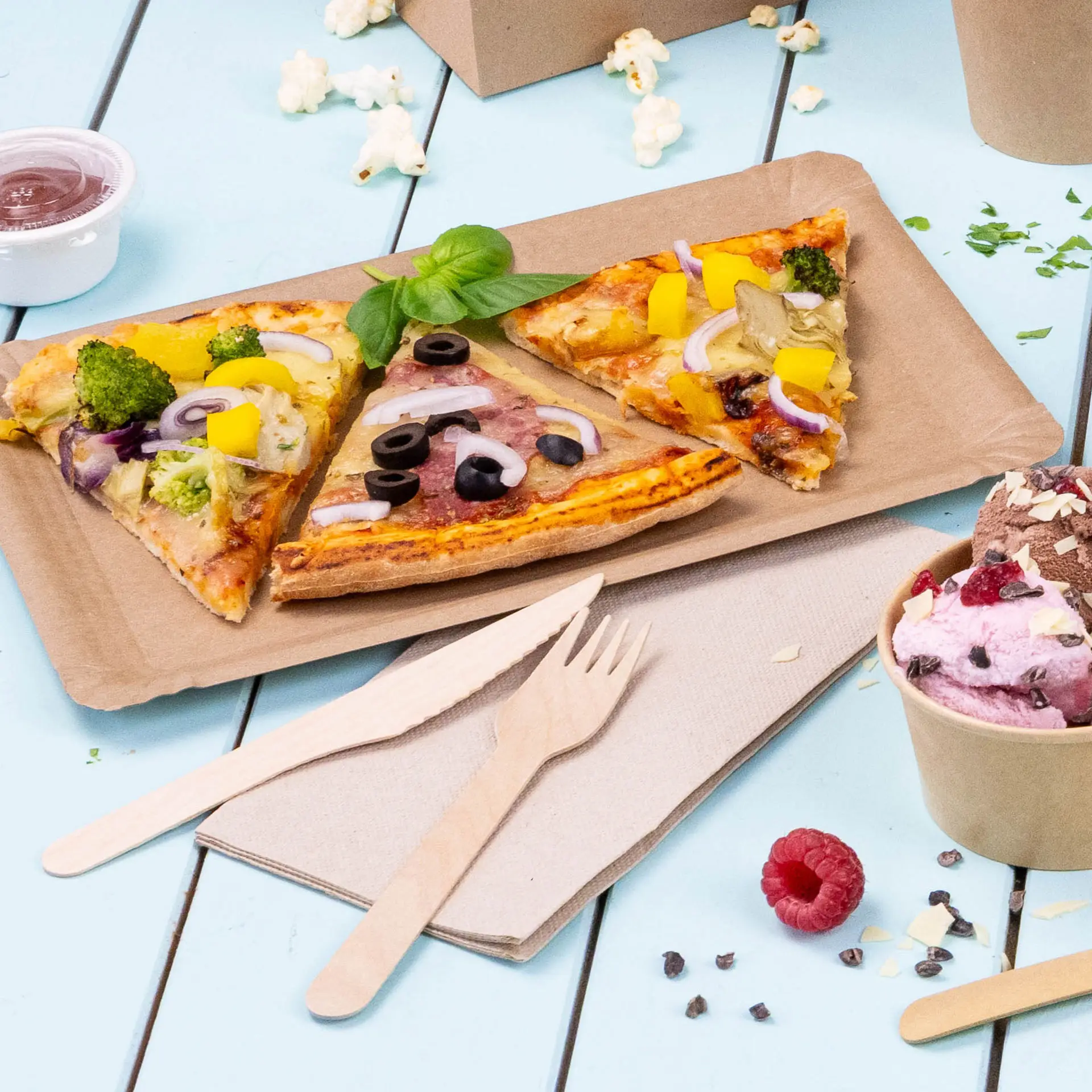 Immagine di tre fette di pizza su un vassoio di carta marrone, con posate di legno e un bicchiere di gelato vicino.