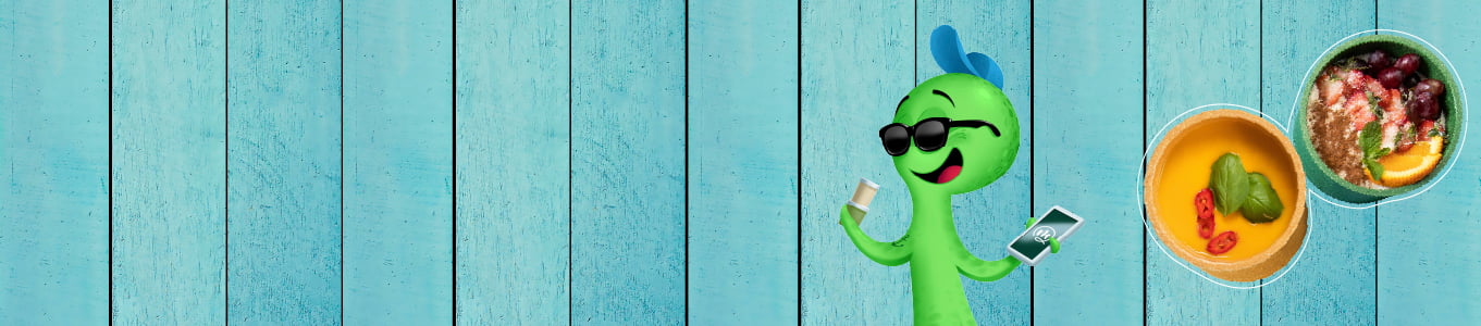 Personaggio cartoon verde con occhiali da sole, tiene un drink e un telefono, con ciotole di cibo su uno sfondo in legno blu.