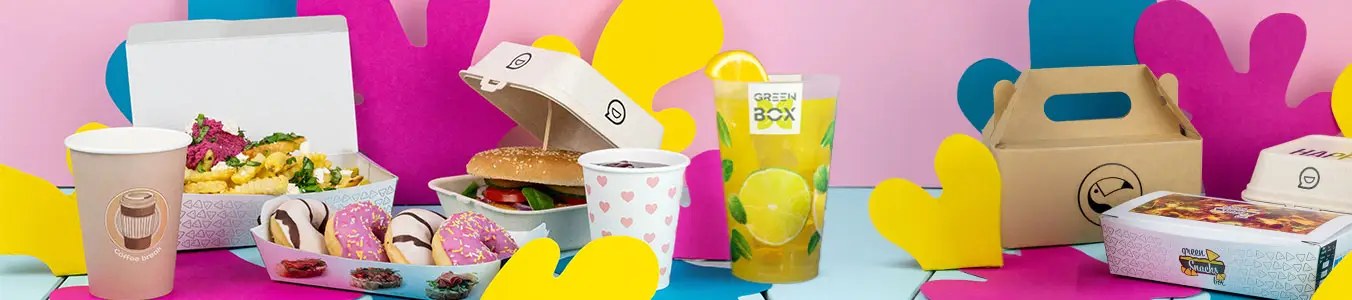Vari articoli personalizzabili disposti su una superficie turchese, tra cui una tazza, cannucce di carta, un tovagliolo e un biglietto con un messaggio di sostenibilità.