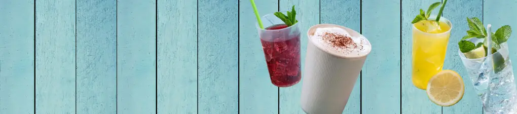 Personaggio verde con un cartello accanto a due bevande; un caffè e una bevanda fredda su uno sfondo blu in legno.