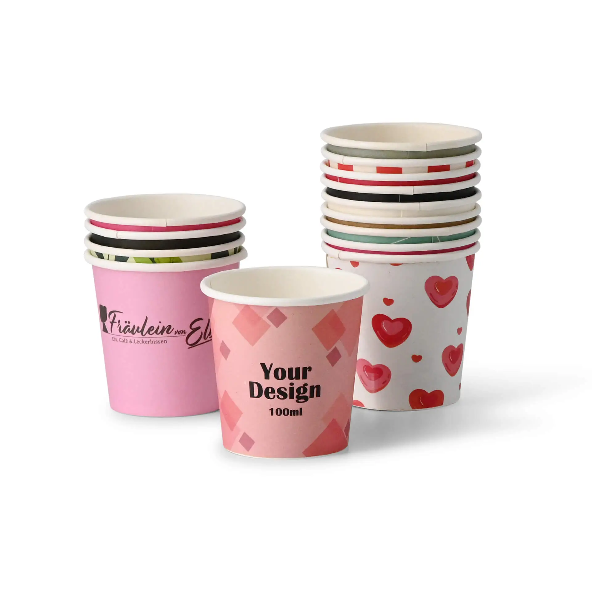 Un bicchiere di carta rosa con un design personalizzato con il testo "Your Design 100ml"; diversi bicchieri decorati impilati dietro.