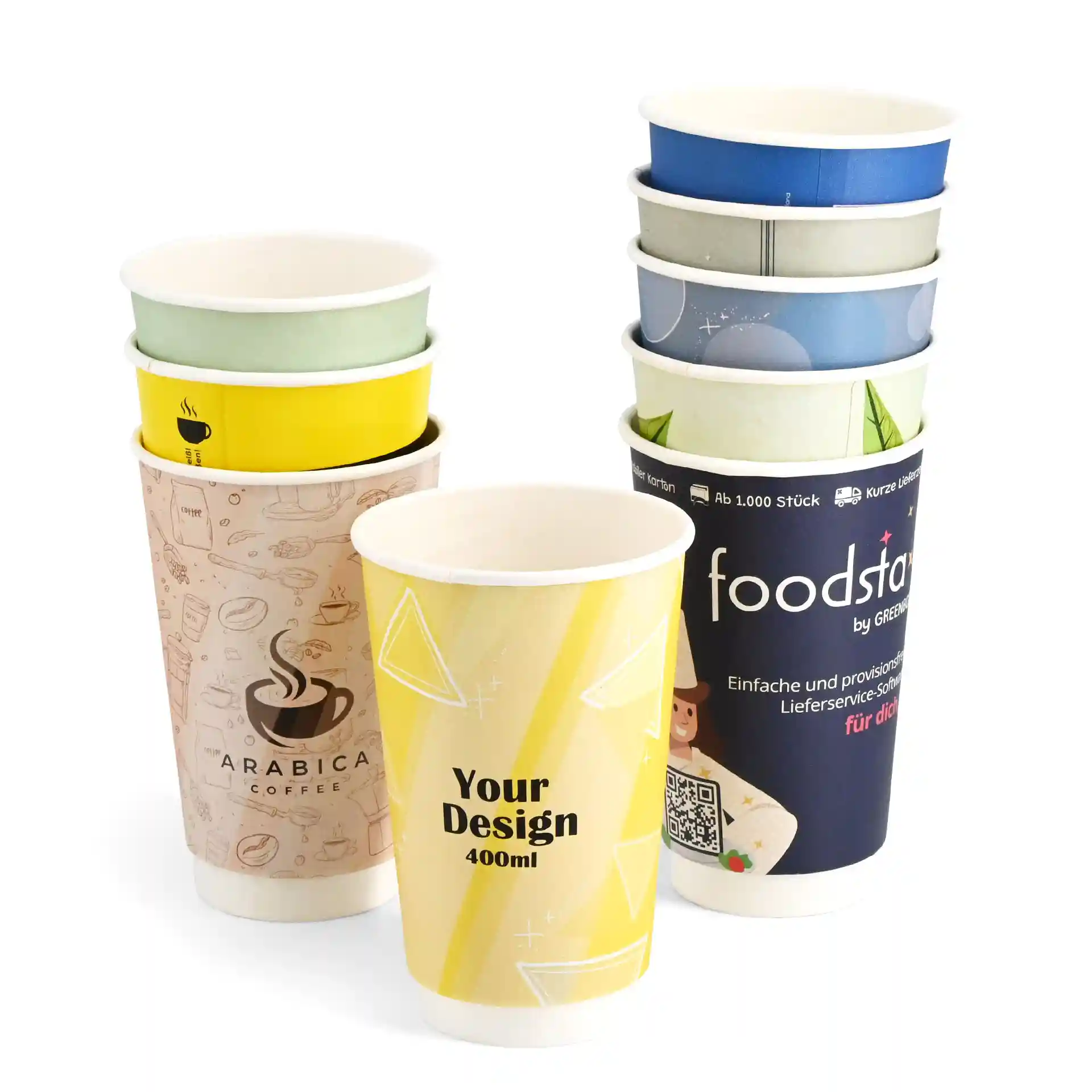 Pila di bicchieri di carta personalizzati con vari design, incluso un bicchiere giallo con "Il tuo design" e un design Arabica caffè.