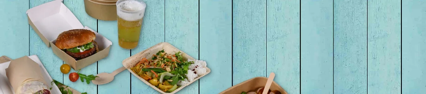 Varietà di cibi da festival su una superficie in legno turchese; include un hamburger, insalata e un bicchiere di birra.