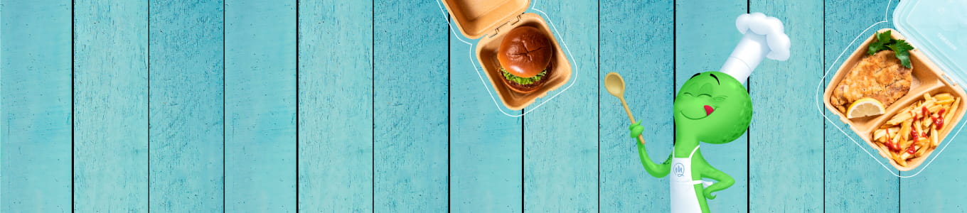 Personaggio chef con testa verde e cappello bianco, in mano un cucchiaio; due contenitori di cibo con un hamburger e un pasto con patatine e pollo su uno sfondo di legno azzurro.
