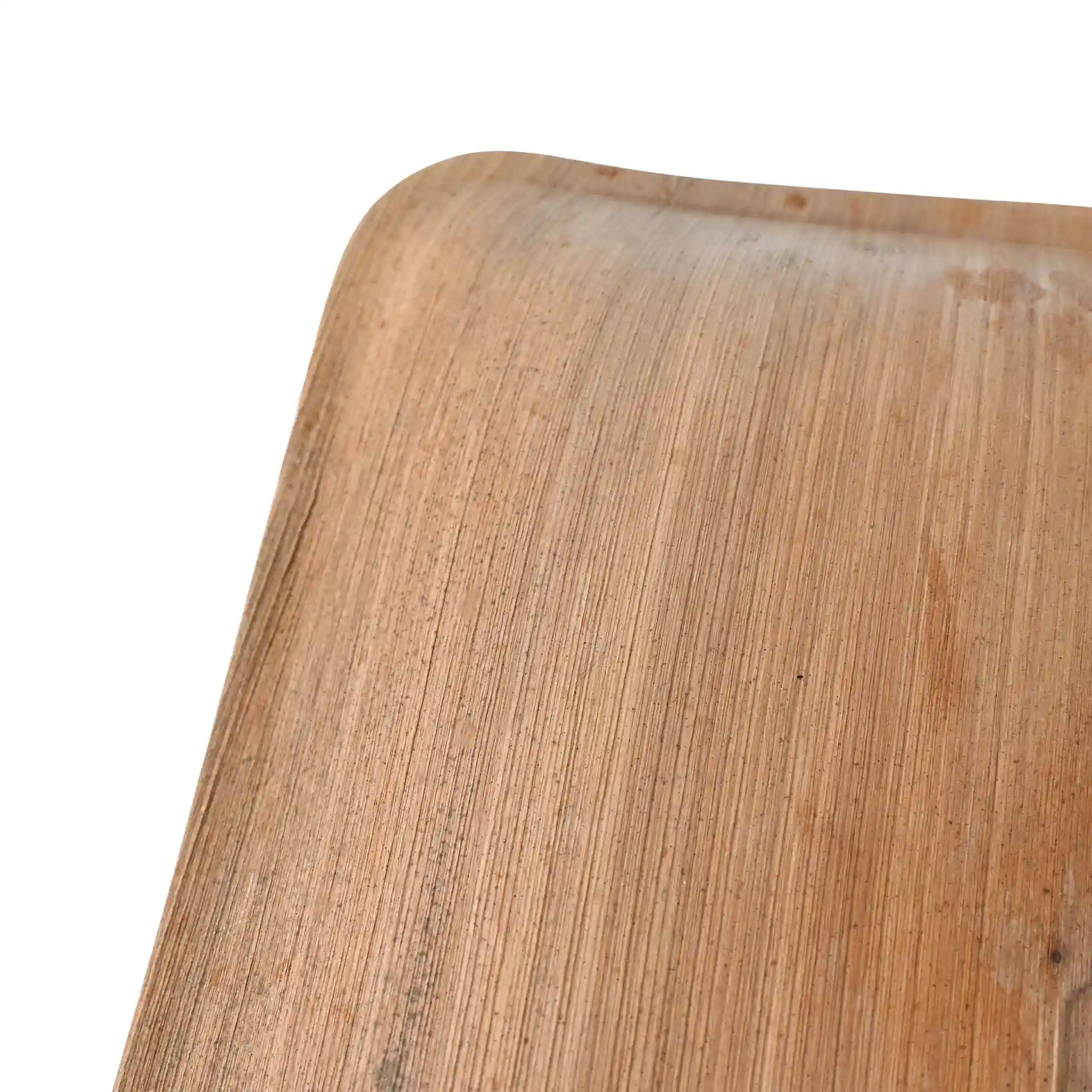Primo piano di un piatto quadrato in foglia di palma con una texture a grana naturale su sfondo bianco.