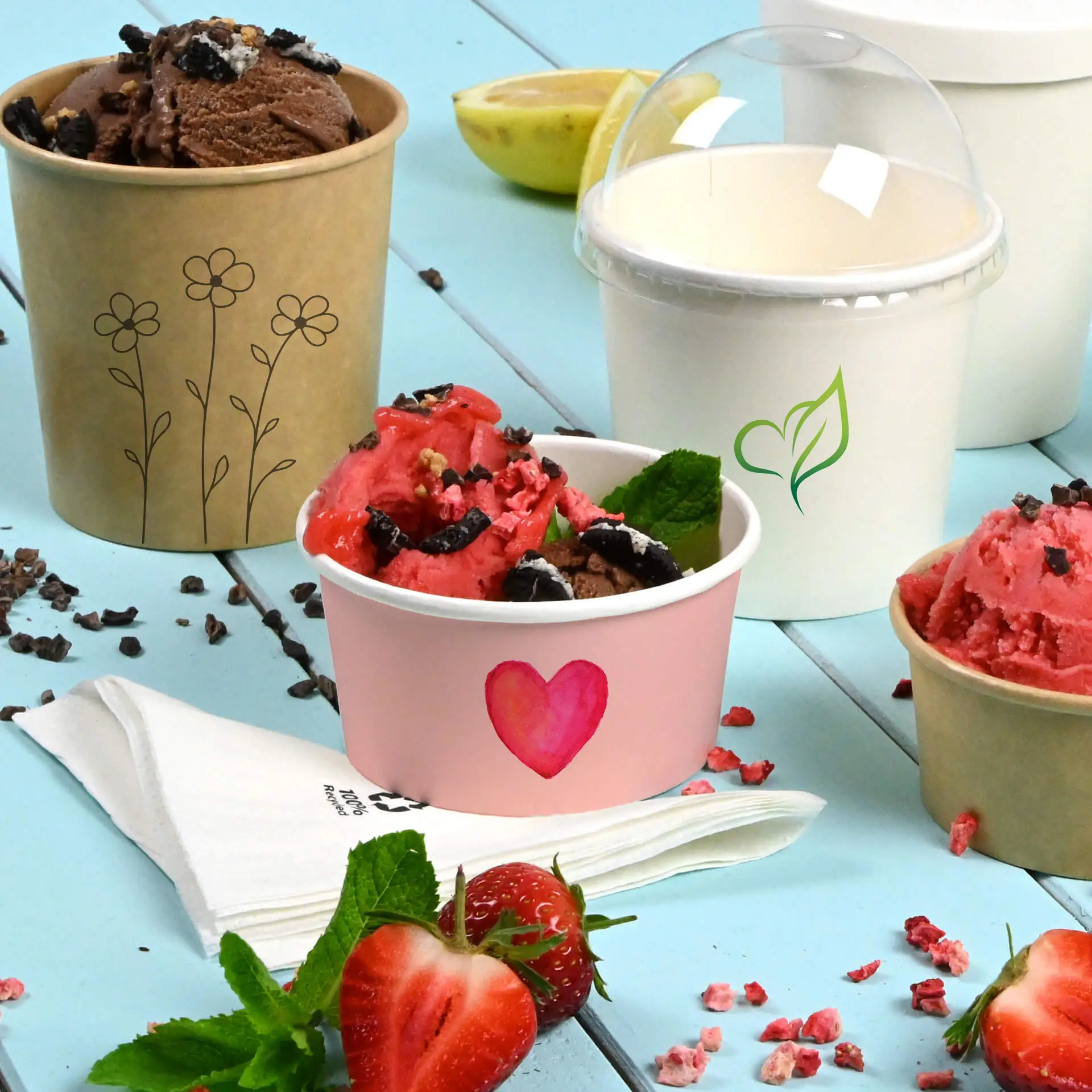 L'immagine presenta colorati bicchieri di gelato, tra cui un bicchiere rosa con un design a cuore, un bicchiere marrone con fiori e un bicchiere bianco con una foglia verde.