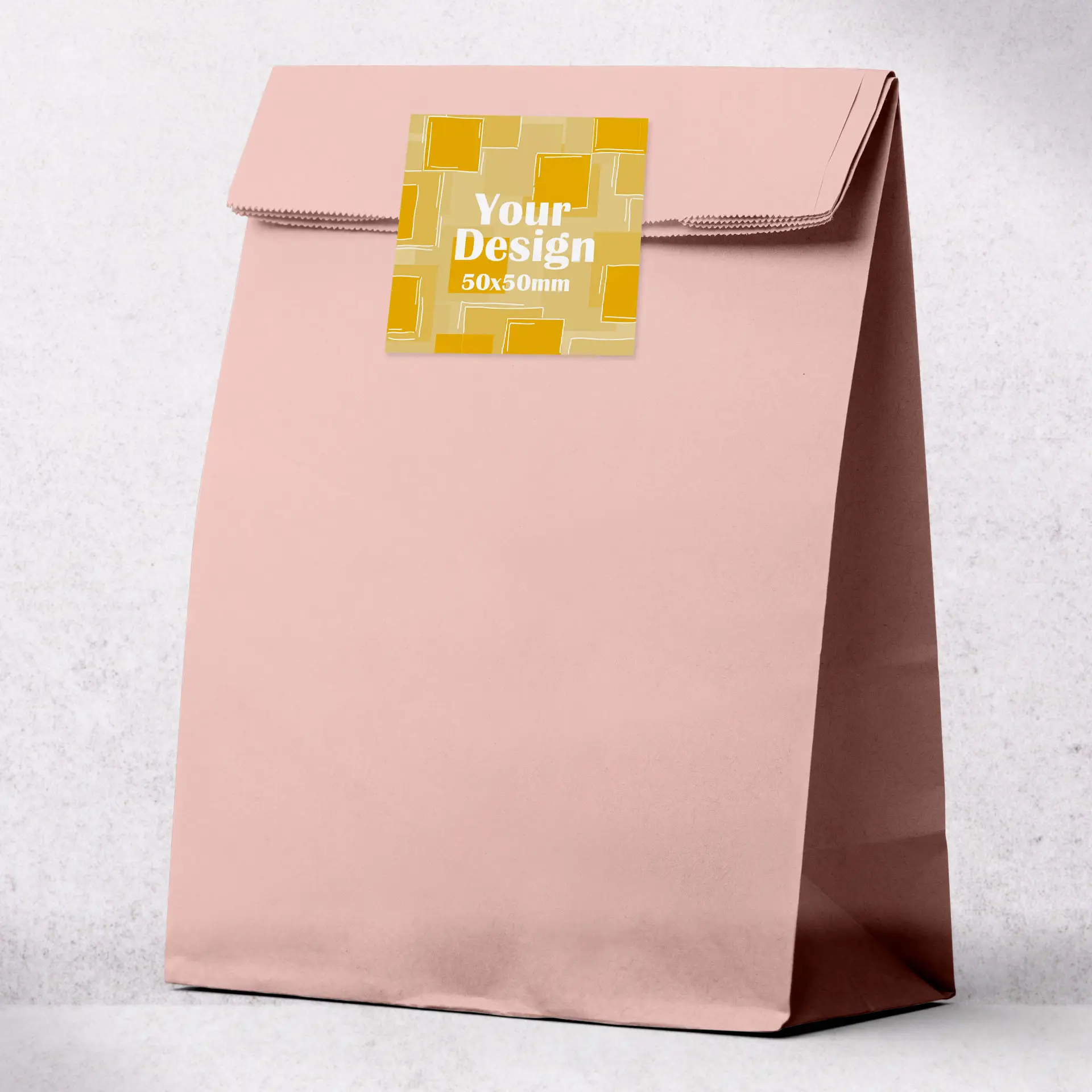 Borsa di carta rosa personalizzata con un'area per etichetta quadrata, progettata per la stampa personalizzata, su sfondo chiaro.