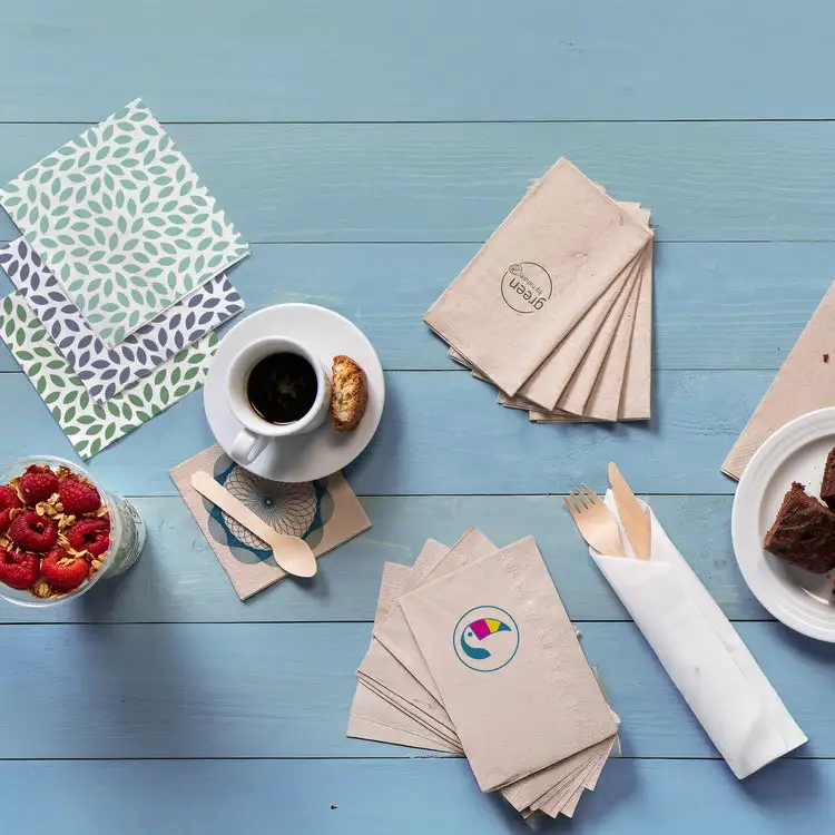 Allestimento della tavola con tovaglioli decorati, tazza con biscotto, dessert e lamponi freschi in un bicchiere.