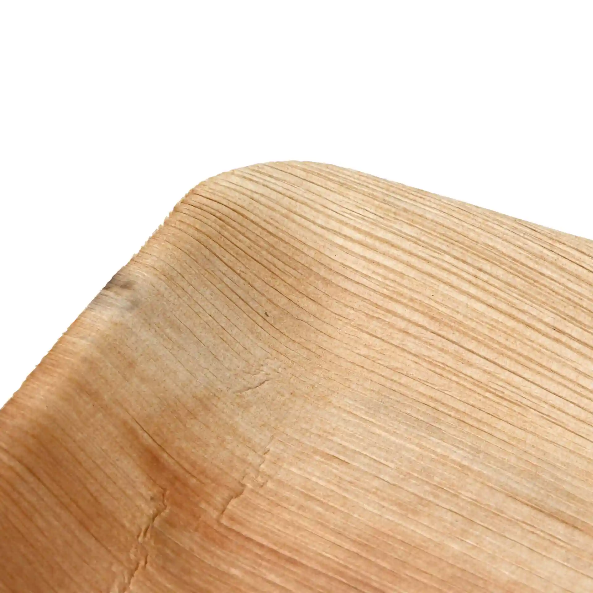 Primo piano di un piatto rettangolare in foglia di palma con texture del grano visibile e bordi arrotondati.