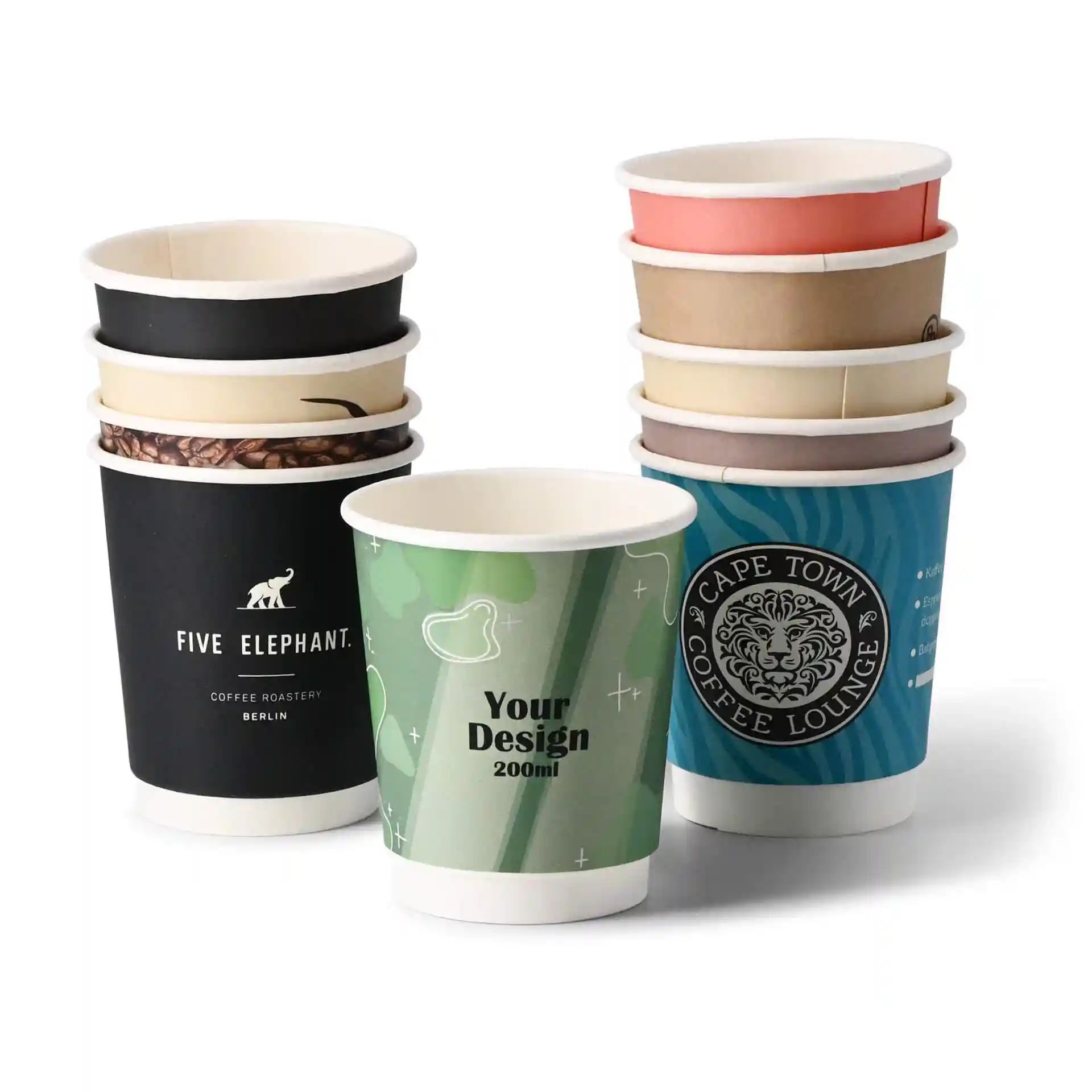 Pila di bicchieri di carta personalizzati in vari design, incluso un bicchiere verde con etichetta "Il tuo design", su sfondo bianco.