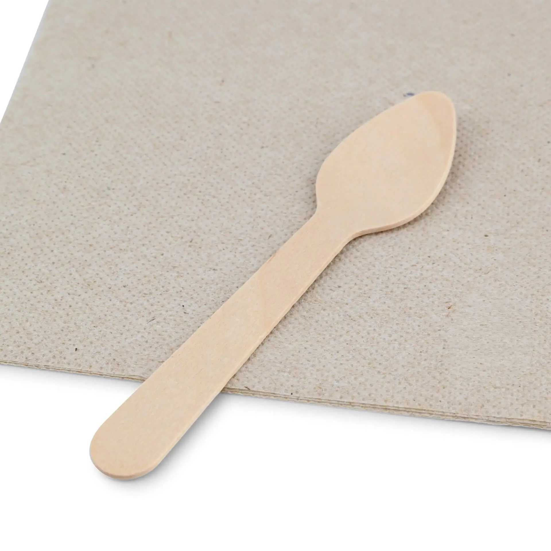 Cucchiaino in legno per espresso, lungo 11 cm, posato su una superficie marrone testurizzata con un simbolo di riciclaggio vicino.