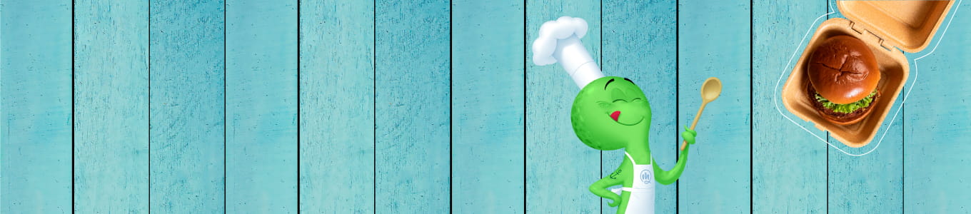 Personaggio dello chef cartone verde con un cucchiaio, accanto a un hamburger in una scatola da asporto marrone su uno sfondo in legno blu.
