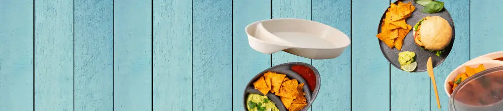 Personaggio cartoon verde accanto a un piatto di nachos, insalata e un panino su uno sfondo in legno blu.