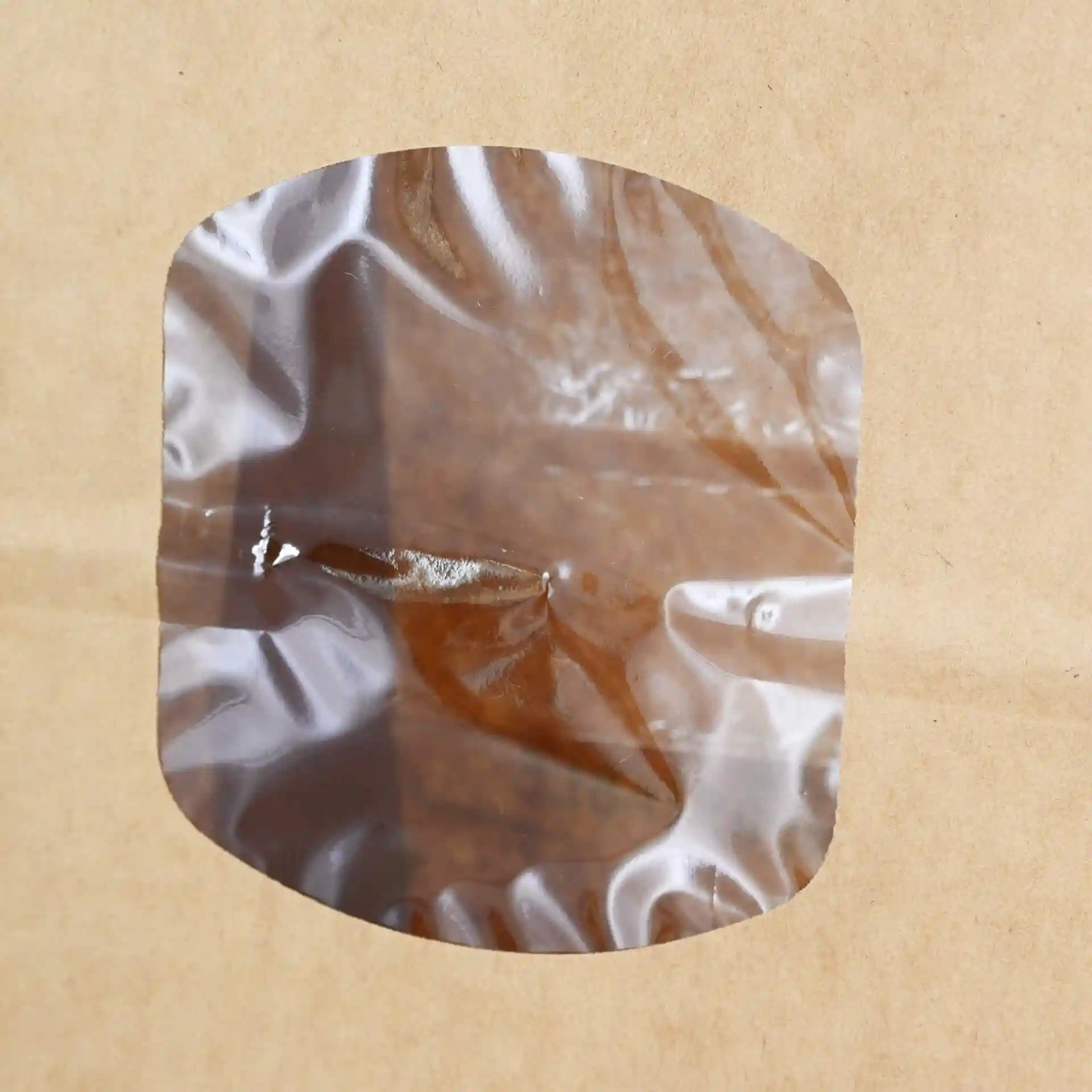 Finestra trasparente su una busta in carta kraft marrone, che mostra il contenuto all'interno.
