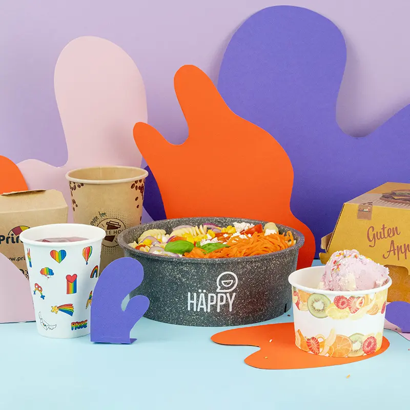 Collezione di articoli per imballaggio alimentare personalizzati, inclusi contenitori, bicchieri e una borsa con varie etichette di design.