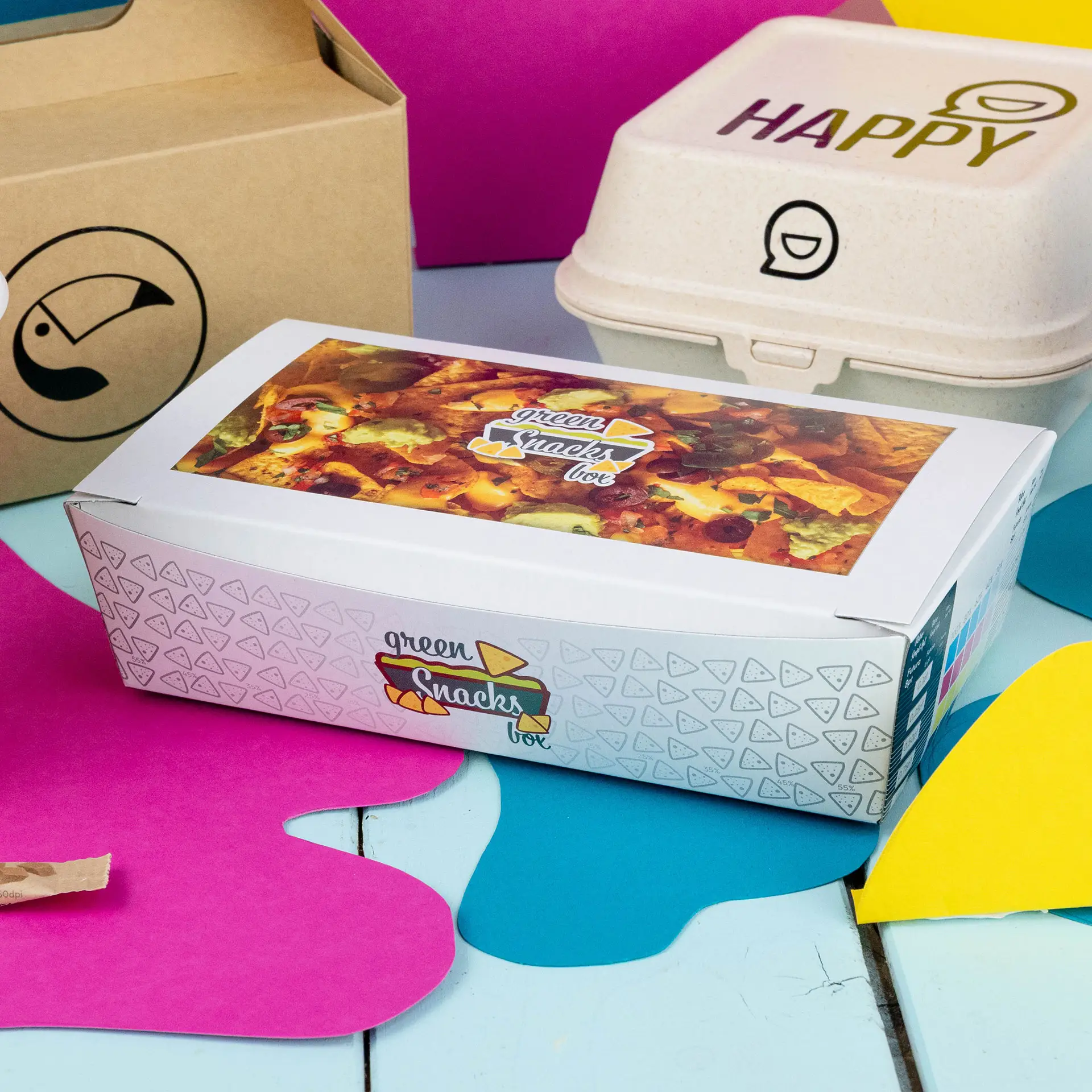 Scatola per snack con design stampato, capacità di 750 ml, posizionata su uno sfondo colorato con altri contenitori vicini.