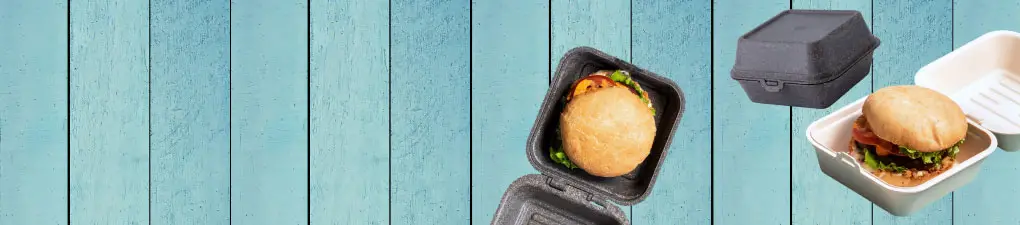 Personaggio dello chef cartone verde con un cucchiaio, accanto a un hamburger in una scatola da asporto marrone su uno sfondo in legno blu.