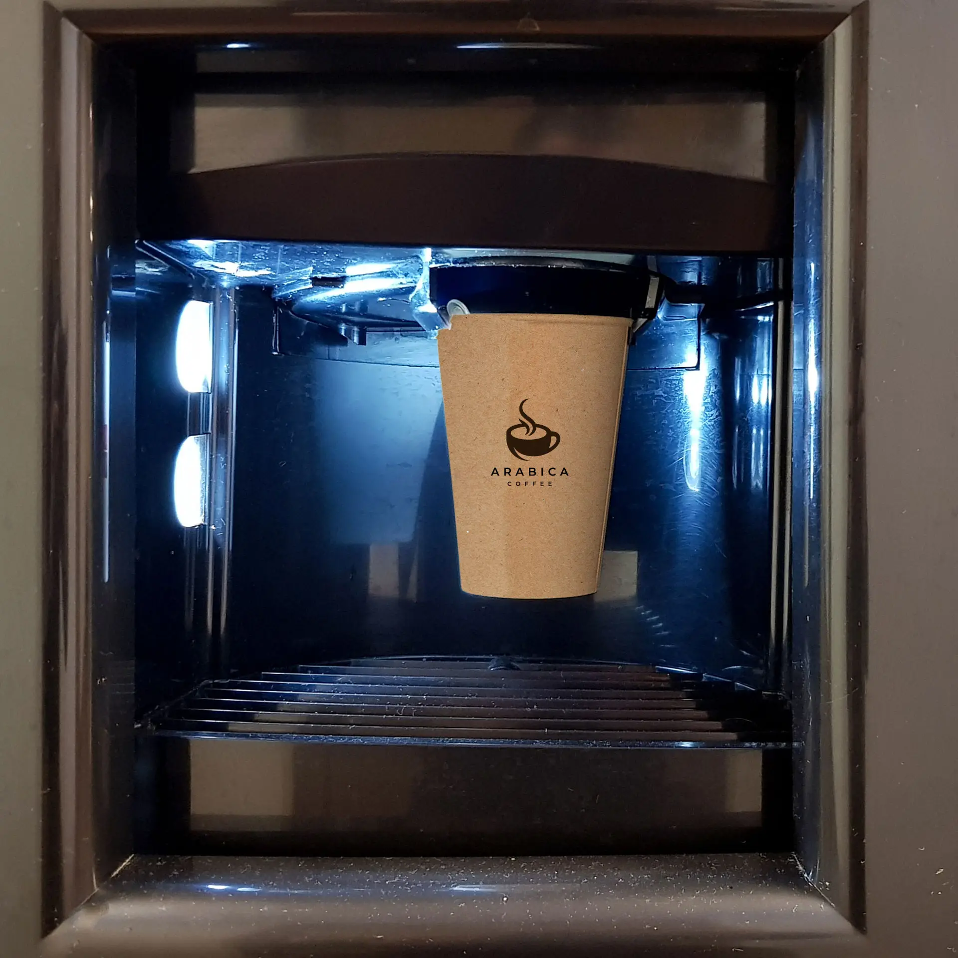 Una tazza di carta marrone con un logo di caffè Arabica mostrata in una macchina per caffè.