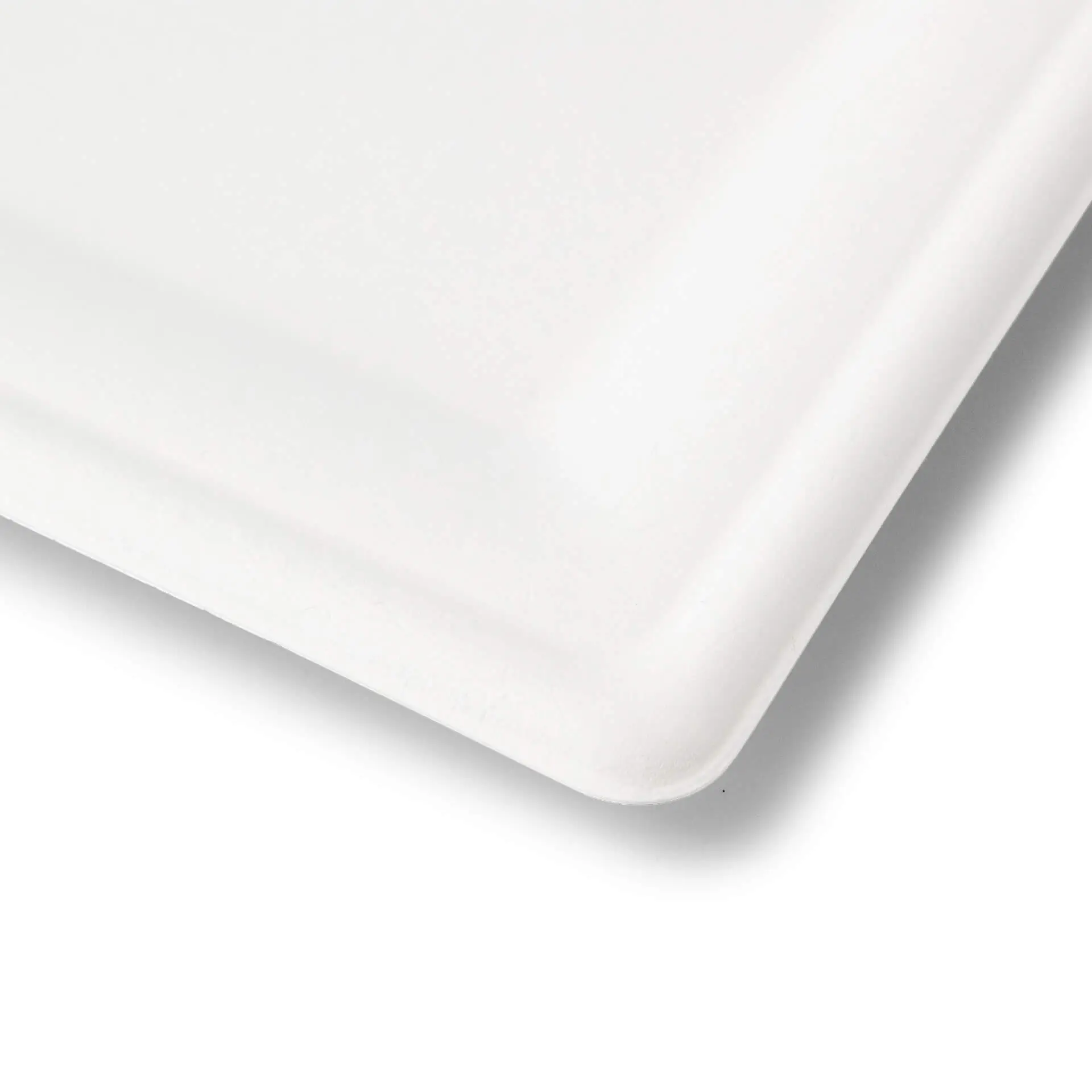 Un piatto quadrato bianco in canna da zucchero con bordi curvi, adatto per cibi caldi e freddi, mostrato di lato.