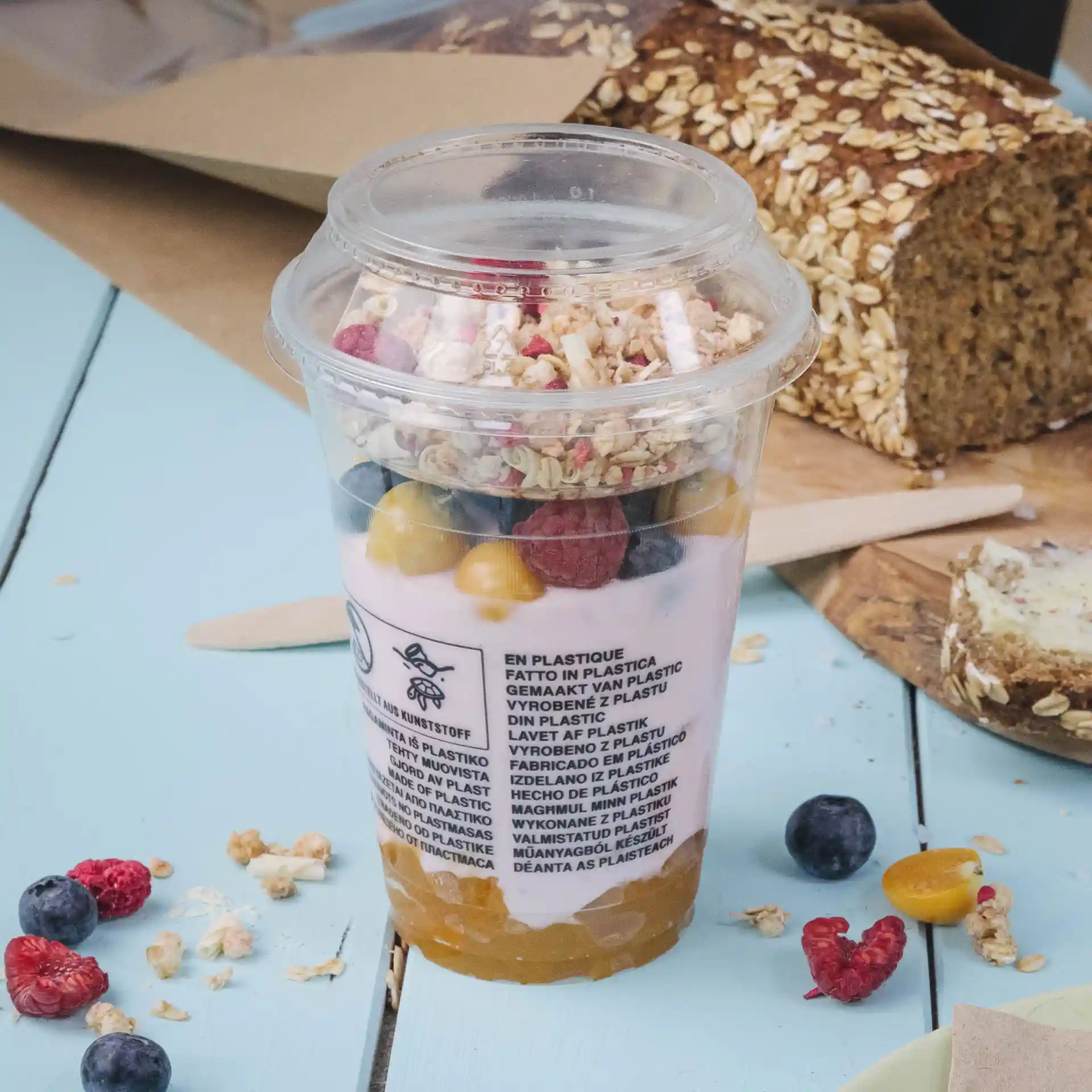 Bicchiere di plastica trasparente riempito di yogurt, granola e frutta mista, con un diametro di 95 mm.
